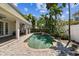 Inviting backyard pool and covered patio surrounded by lush tropical landscaping at 3710 W San Pedro St, Tampa, FL 33629