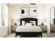 Comfortable bedroom with a black bed frame, neutral colored bedding, and matching nightstands at 3716 Forest Path Dr, Plant City, FL 33565