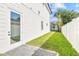 Backyard view showing white fenced in yard with grass and a door leading to interior of the house at 3821 W Vasconia St, Tampa, FL 33629