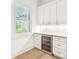 Wet bar featuring a wine fridge, marble counters, and shaker-style cabinets at 3821 W Vasconia St, Tampa, FL 33629