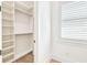 White closet with installed shelving units and natural light from the window at 3821 W Vasconia St, Tampa, FL 33629