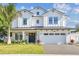 Stunning two-story white farmhouse with a black metal roof and an attached two car garage at 3821 W Vasconia St, Tampa, FL 33629