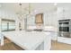 A stunning kitchen features a large central island, stainless steel appliances, quartz countertops, and ample cabinet space at 3821 W Vasconia St, Tampa, FL 33629