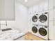 Laundry room with front loading washer and dryers and marble countertop at 3821 W Vasconia St, Tampa, FL 33629