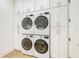 Laundry room featuring front loading washer and dryers and white cabinets at 3821 W Vasconia St, Tampa, FL 33629