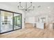 An open-concept living room features light wood floors, modern lighting fixtures, and sliding glass doors to the outdoor kitchen at 3821 W Vasconia St, Tampa, FL 33629