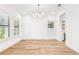Bright, open living room with hardwood floors, modern light fixture, and large windows at 3821 W Vasconia St, Tampa, FL 33629