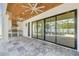 Inviting outdoor kitchen and living space with travertine floors, wood ceiling, and expansive sliding glass doors at 3821 W Vasconia St, Tampa, FL 33629