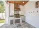 Outdoor kitchen featuring stainless steel grill, sink, granite countertop, and travertine tile flooring at 3821 W Vasconia St, Tampa, FL 33629