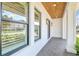 Covered front porch with brick floor, wood ceiling, and three paned windows looking into the home at 3821 W Vasconia St, Tampa, FL 33629