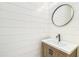 Powder room with shiplap walls, wood vanity, and round mirror at 3821 W Vasconia St, Tampa, FL 33629