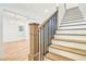 Staircase with hardwood treads and wrought iron railing, with a peek into another room at 3821 W Vasconia St, Tampa, FL 33629