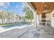 Stunning outdoor pool and kitchen area with travertine tile, outdoor seating, and well-manicured landscaping at 3821 W Vasconia St, Tampa, FL 33629