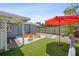 Inviting backyard oasis with a firepit, artificial grass, and shaded lounge area, perfect for outdoor entertaining at 4013 W Waterman Ave, Tampa, FL 33609
