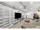 Finished basement with entertainment space, modern shelving, and nearby laundry at 4013 W Waterman Ave, Tampa, FL 33609