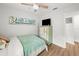 Bright bedroom with a coastal theme featuring a modern ceiling fan and a TV on the dresser at 4013 W Waterman Ave, Tampa, FL 33609
