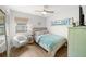 Bright bedroom featuring a ceiling fan, beach-themed decor, and light wood floors at 4013 W Waterman Ave, Tampa, FL 33609