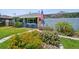Blue house with vibrant flowers, an American flag, manicured lawn, and screened in porch in the back at 4013 W Waterman Ave, Tampa, FL 33609