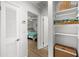 Hallway view leading to a bedroom with white walls and shelving for towels and baskets at 4013 W Waterman Ave, Tampa, FL 33609