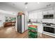 Open-concept kitchen with stainless steel appliances, white cabinets, and a view into the living room at 4013 W Waterman Ave, Tampa, FL 33609