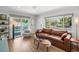 Well-lit living room with a view of the pool, hardwood floors, and a comfortable seating arrangement at 4013 W Waterman Ave, Tampa, FL 33609