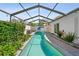 Charming backyard featuring a screened-in pool, lush greenery, and a pristine poolside at 4013 W Waterman Ave, Tampa, FL 33609