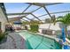 Beautiful screened-in pool with poolside seating, lush greenery, and privacy wall at 4013 W Waterman Ave, Tampa, FL 33609