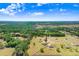 Expansive aerial view of a property surrounded by lush greenery and scattered homes at 41043 Stanton Hall Dr, Dade City, FL 33525