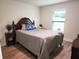 Comfortable bedroom featuring wood-look floors, natural light, and a decorative headboard at 41043 Stanton Hall Dr, Dade City, FL 33525