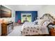Cozy bedroom features a comfortable bed, accent wall, and a sunny window offering peaceful view at 41043 Stanton Hall Dr, Dade City, FL 33525