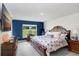 Cozy bedroom features a comfortable bed, accent wall, and a sunny window offering peaceful view at 41043 Stanton Hall Dr, Dade City, FL 33525