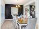 An elegant dining room with a long wooden table, stylish chairs, tile floor, and dark accent wall at 41043 Stanton Hall Dr, Dade City, FL 33525