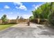 Estate entrance with an ornate iron gate, stone columns, and brick driveway under a sunny sky at 41043 Stanton Hall Dr, Dade City, FL 33525