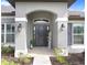 Inviting front entry with decorative pillars, modern lighting, and a charming welcome sign at 41043 Stanton Hall Dr, Dade City, FL 33525