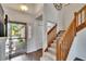 Inviting foyer with wood-look tile, staircase with wood railing, and natural light from the front door at 4225 Barret Ave, Plant City, FL 33566