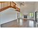 Bright living room featuring hardwood floors, a vaulted ceiling, fireplace, and large windows with a lake view at 4225 Barret Ave, Plant City, FL 33566