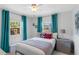 Cozy bedroom with two windows, bright turquoise curtains and stylish bedding, creating a serene and inviting atmosphere at 5254 23Rd N Ave, St Petersburg, FL 33710