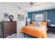 Comfortable bedroom featuring an orange comforter, stylish wall art, and natural light from the window at 5254 23Rd N Ave, St Petersburg, FL 33710