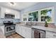 Well-lit kitchen featuring stainless steel appliances, granite countertops, white cabinets, and a window overlooking a lush backyard at 5254 23Rd N Ave, St Petersburg, FL 33710