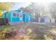 Private backyard with a turquoise house, storage shed, and mature trees at 56 W Park St, Tarpon Springs, FL 34689