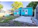Charming backyard with a turquoise house, shed, patio, and fenced yard at 56 W Park St, Tarpon Springs, FL 34689
