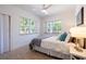 Bright bedroom featuring soft carpet, a ceiling fan, and two large windows at 56 W Park St, Tarpon Springs, FL 34689