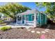 Charming turquoise home with a welcoming white-railed front porch and manicured landscaping, offering curb appeal at 56 W Park St, Tarpon Springs, FL 34689