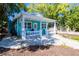 Charming turquoise home featuring a inviting front porch with white railings and a meticulously landscaped yard at 56 W Park St, Tarpon Springs, FL 34689