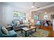 Bright living room featuring hardwood floors, ceiling fan, large windows, and stylish decor, creating a welcoming atmosphere at 56 W Park St, Tarpon Springs, FL 34689