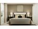 Stylishly decorated bedroom showcasing a comfortable bed, neutral color palette, modern art, and bedside lamps for a relaxing ambiance at 5611 Red Kite Dr, Wimauma, FL 33598