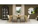 Elegant dining room with a display cabinet, large window, and stylish modern decor at 5611 Red Kite Dr, Wimauma, FL 33598