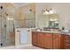 Modern bathroom with glass shower, dual sink vanity, granite counters, and wooden cabinets at 601 Bosphorous Ave, Tampa, FL 33606
