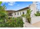Elegant two-story home with a tile roof, white stucco, balcony, and lush tropical landscaping at 601 Bosphorous Ave, Tampa, FL 33606