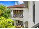 Exterior view of a charming two-story home featuring a balcony and surrounded by lush, tropical foliage at 601 Bosphorous Ave, Tampa, FL 33606